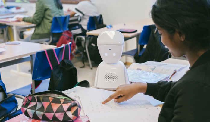 Av1 robot deltar i undervisningen for en elev som ikke kan være til stede i klasserommet. Her jobber roboten sammen med en annen elev. 