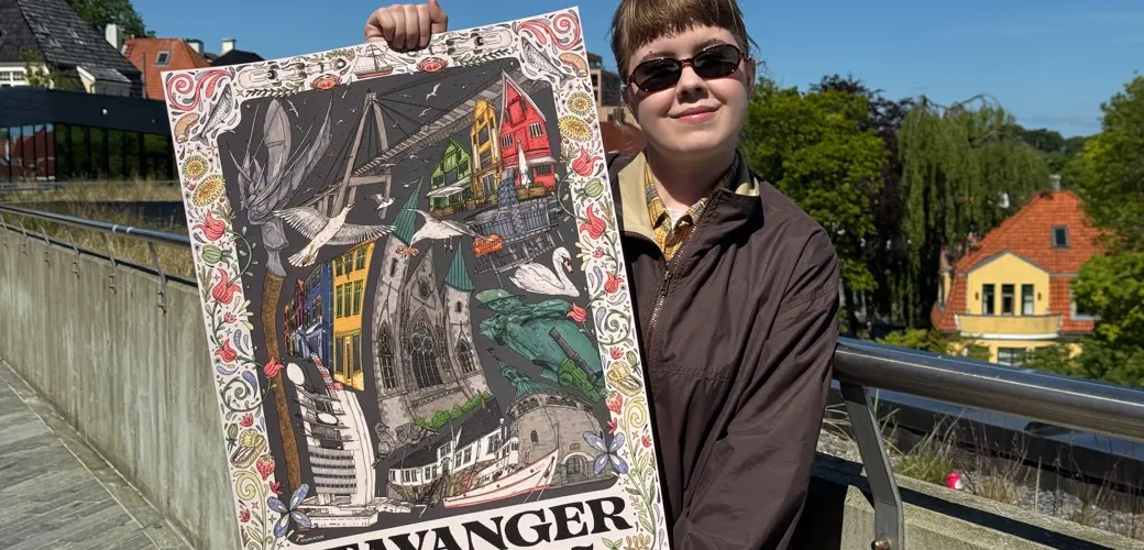 Kunstner Johanna Warberg smiler fornøyd med Jubileumsplakaten 2025 i hånden.  Kunstner Johanna Warberg smiler fornøyd med Jubileumsplakaten 2025 i hånden.