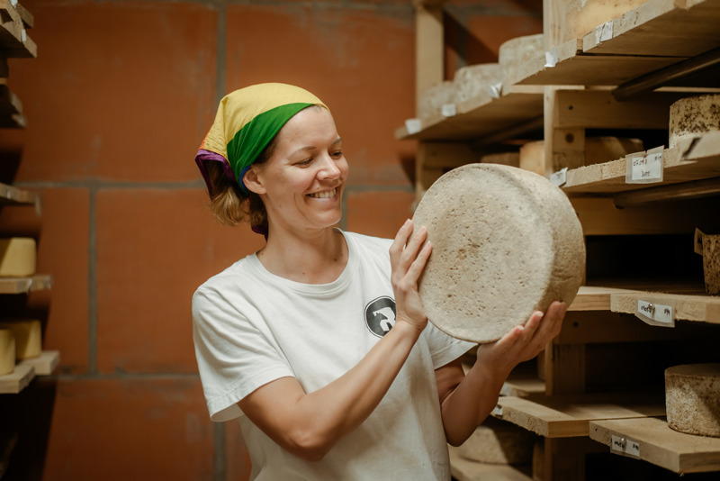 Kvinne holder en stor ost. 