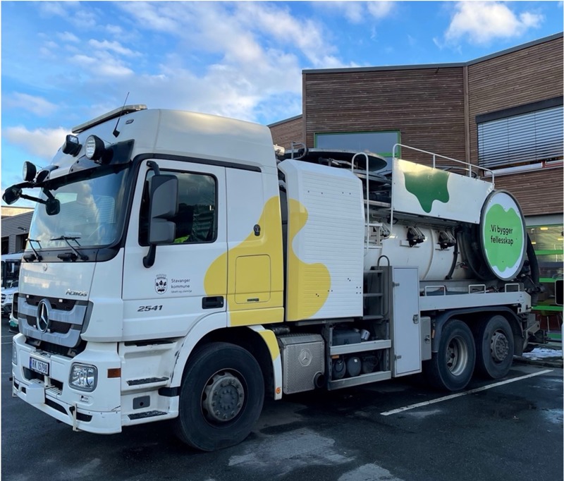 En stor tankbil med gul, skogsgrønn og grønn øyform