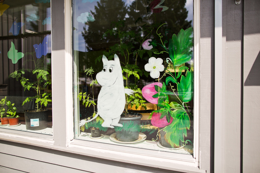 En mumitrollfigur i papp i et vindu