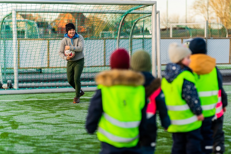 Mann spiller fotball med barn