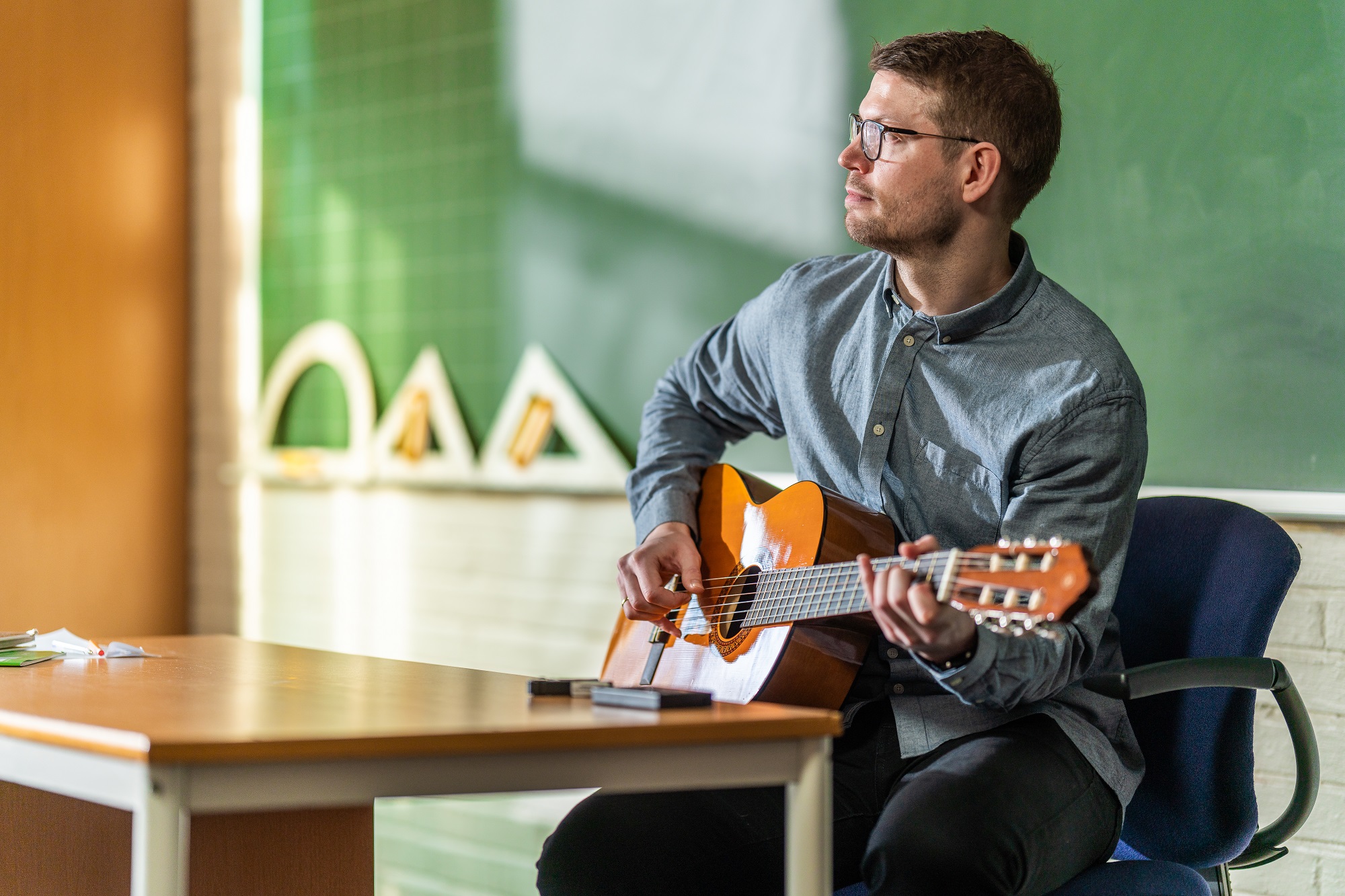 lærer som spiller på gitar i klasserom