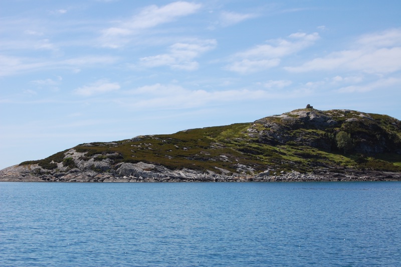 Liten holme med lynghei og berg.