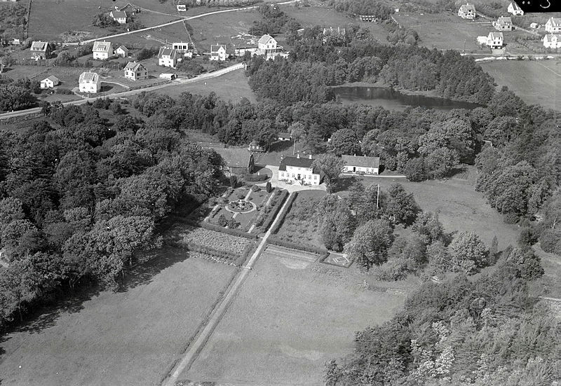 Lystgård med prakthage og park med dam omkring. Nyere villabebyggelse mot øverste bildekant, over Hinnasvingene, fotgrafert fra fly.