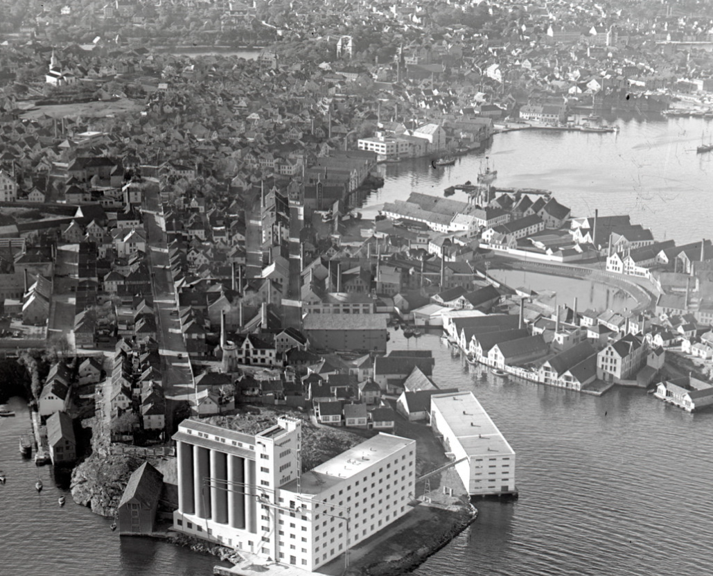 Området ved Verven, Badedammen og Nordkronen mølle fotografert fra fly i 1930-årene. Mange høye fabrikkpiper stikker opp mellom sjøhus, fabrikkbygninger og bolighus.