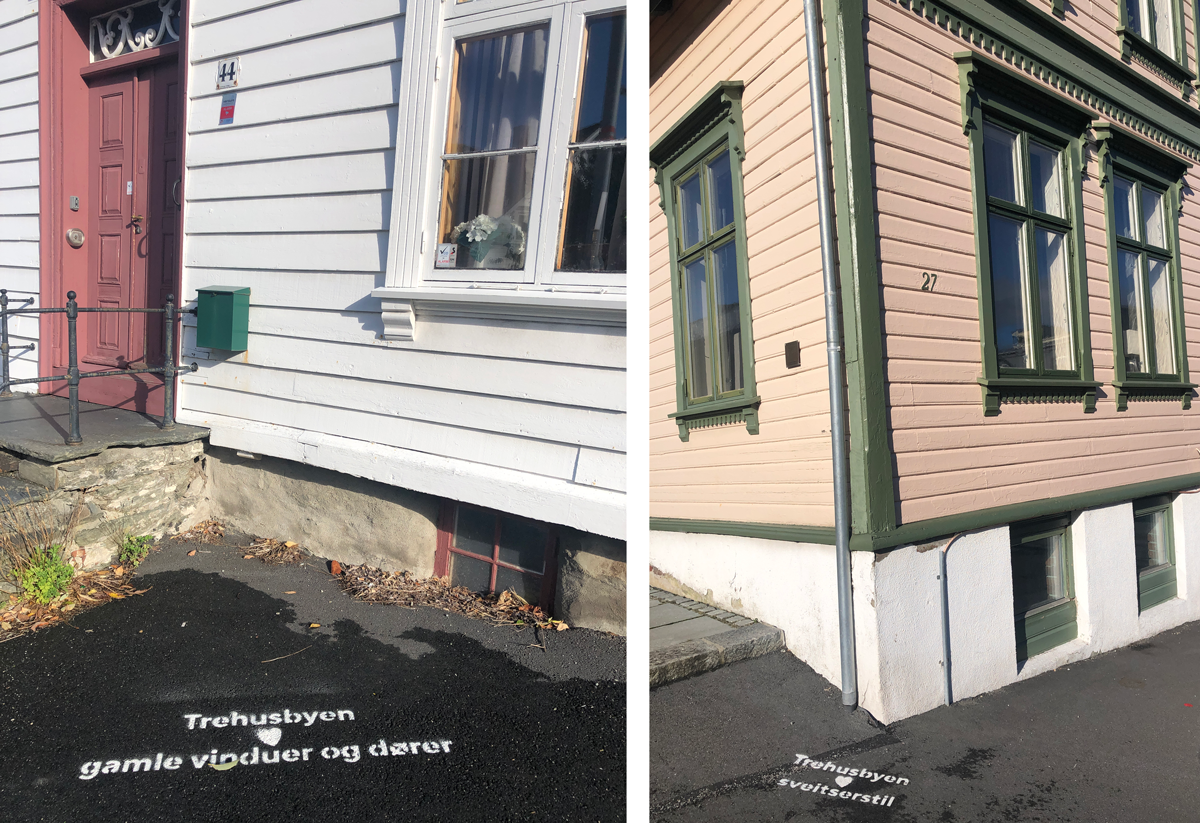 Budskap på asfalten foran eksemplariske hus: "Trehusbyen elsker gamle dører og vinduer", og "Trehusbyen elsker sveitserstil".  Foto: Sigrun Sætrevik