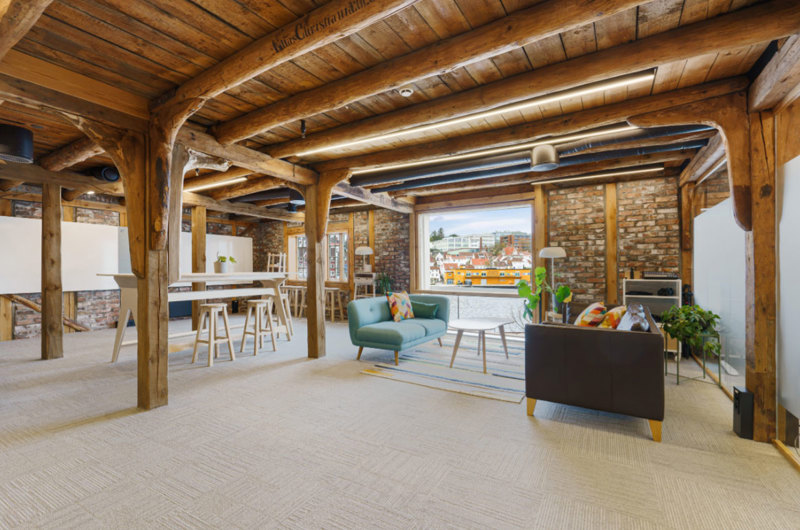 Moderne kontorlokaler med synlig, gammelt treverk og bjelker i taket. Foto: Arve Gravdal 