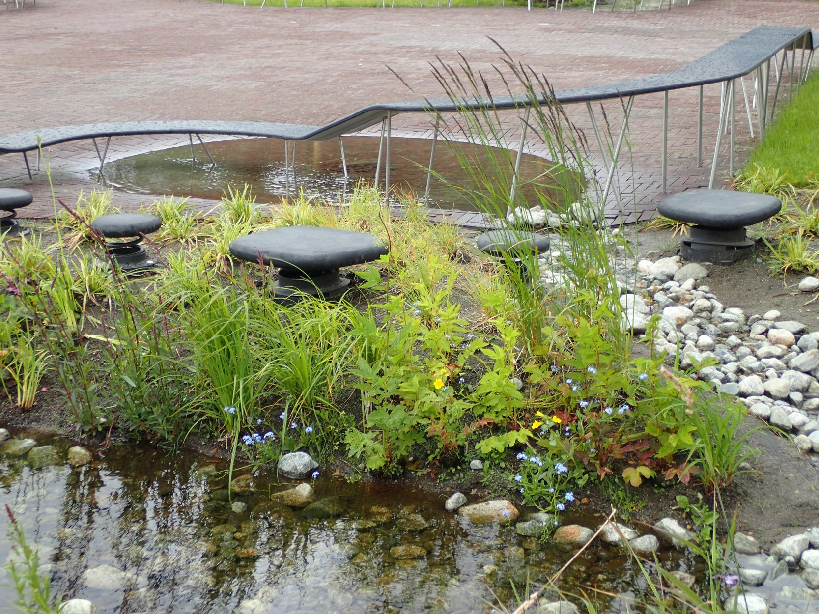 Bekk med steiner og vegetasjon, og apparater barn kan balansere på.