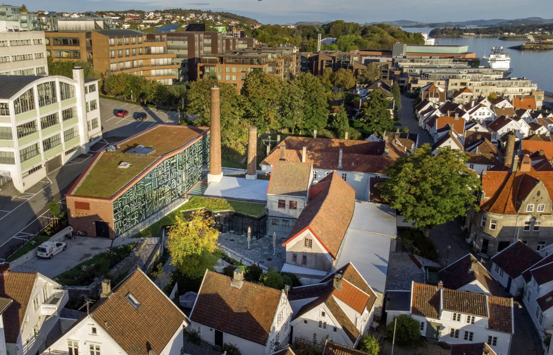 Skala: IDDIS har form og volum som danner en fin overgang mellom de små husene og museet i Gamle Stavanger – og den større bebyggelsen i bakkant. Byggets store vindusfasade er utformet slik at den forteller om innholdet uten å virke dominerende i uterommet. Arkitekt: Eder Biesel arkitekter. Foto: Fredrik Refvem/Stavanger Aftenblad
