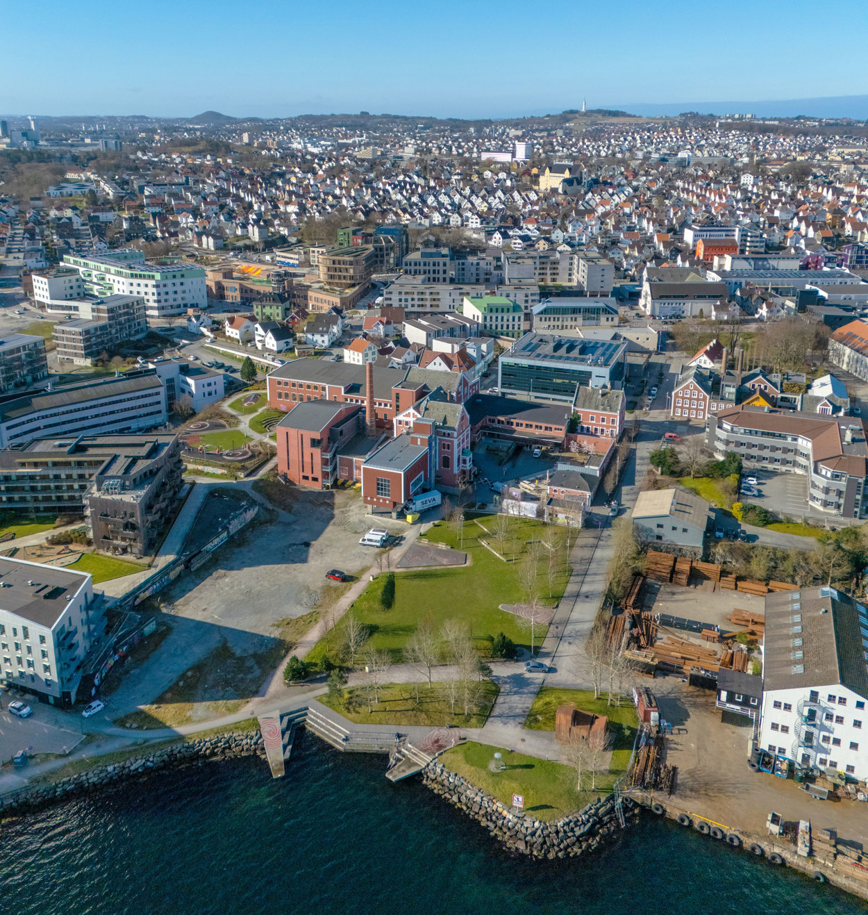 Flyfoto fra østre bydel, med gamle Tou bryggerier midt i bildet. Grønn park til høyre foran Tou, grustomt til venstre