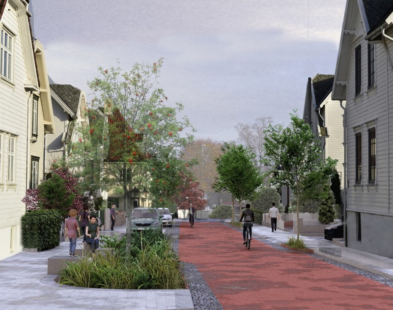 Syklist i bygate med rødt dekke, som viser sykkelprioritert gate