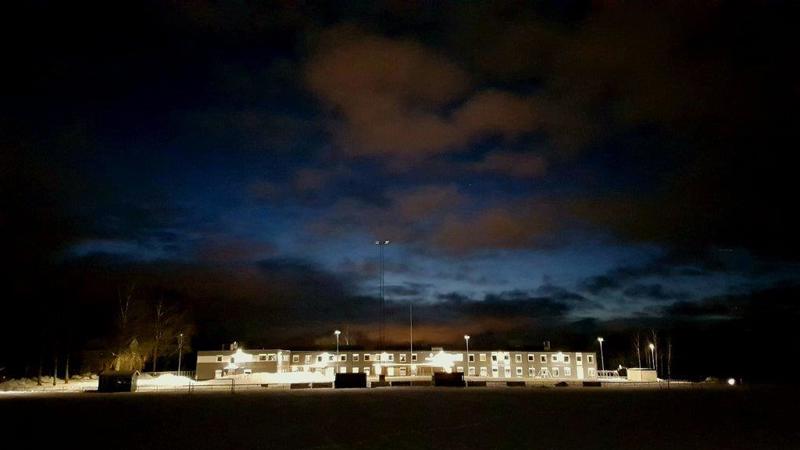 Modulskole i mørket med mørk blå kveldshimmel i bakgrunnen.