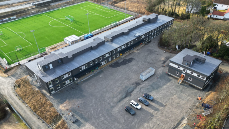 Skolebygg av moduler foran en fotballbane