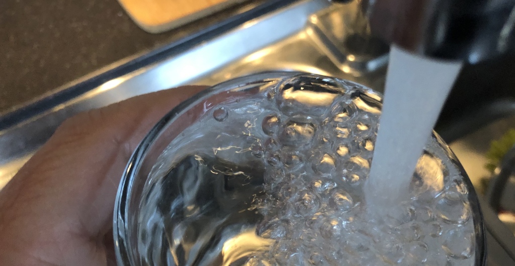 Vann fra spingen renner ned i et glass