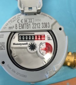 Vannmåler, med telleverk innenfor en rund glassplate.