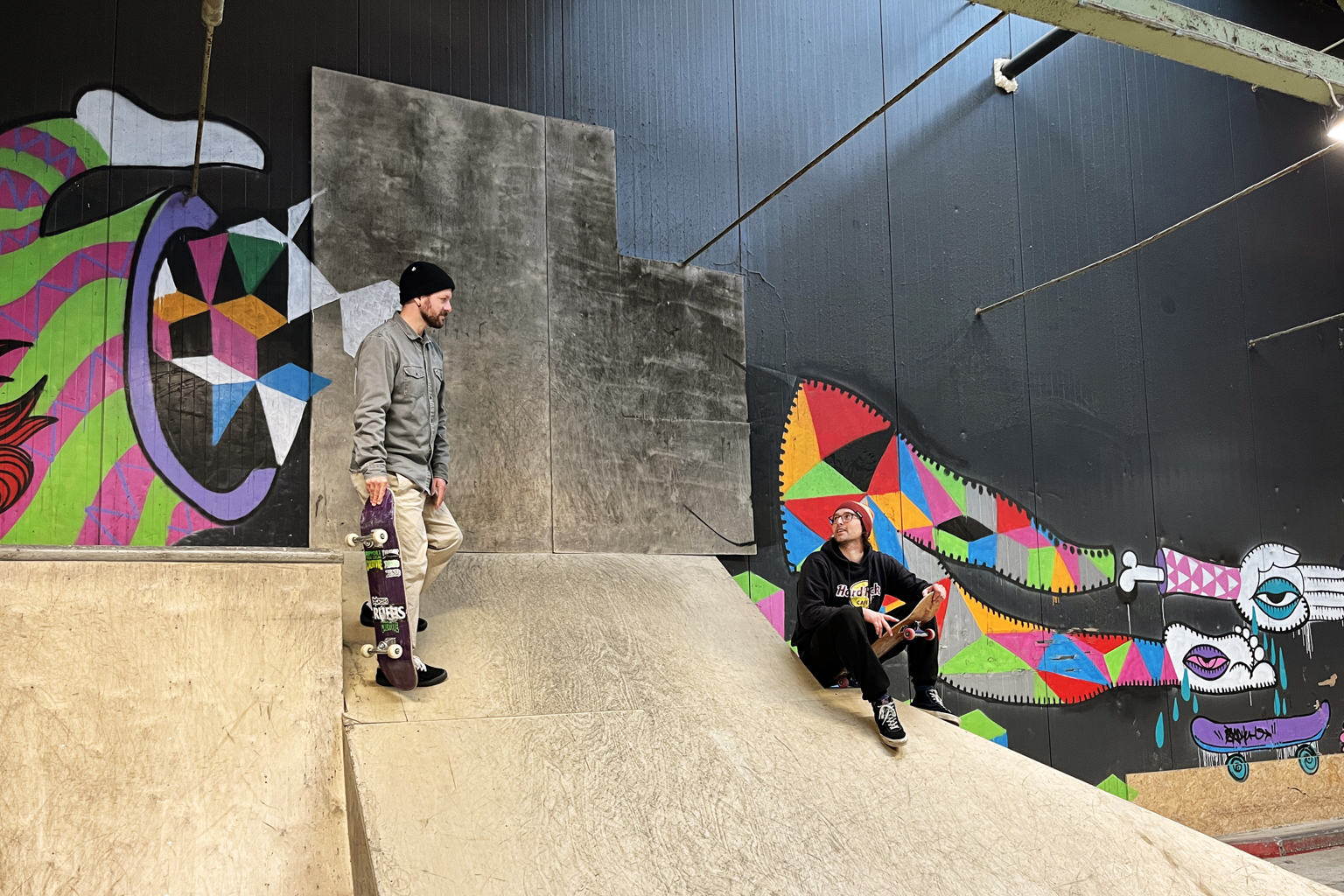 VIL HA FLERE MED: Ole Bjørn Hevrøy og Peter Shpilenia vil gjerne ha flere med i skatehallen. To unge menn med skateboard i skatehallen.