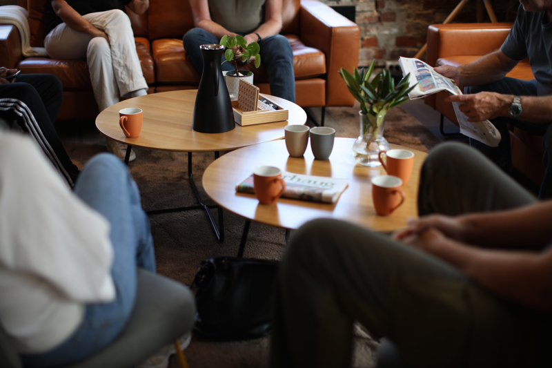 Flere personer som sitter rundt et bord og snakker. 