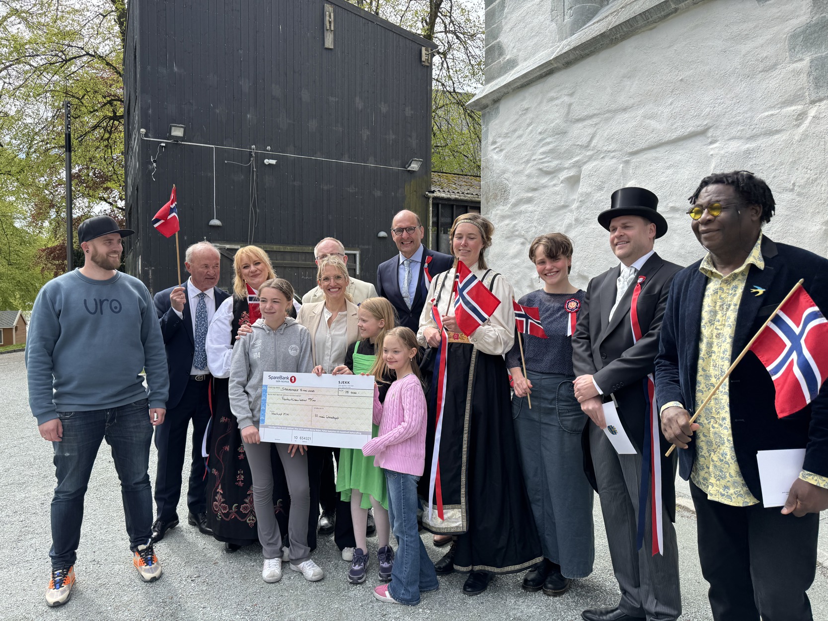 Hurraprisen 2025! Kristin Gjerde Hjelle, Josefine Sofie Eilertsen og Isabella Therese Andersen i 5C på Kvernevik skole mottok prisen sammen med Solveig Gjerde Hjelle og Daniel Eilertsen. På bildet er de omgitt av medlemmene i 17. mai-utvalget.