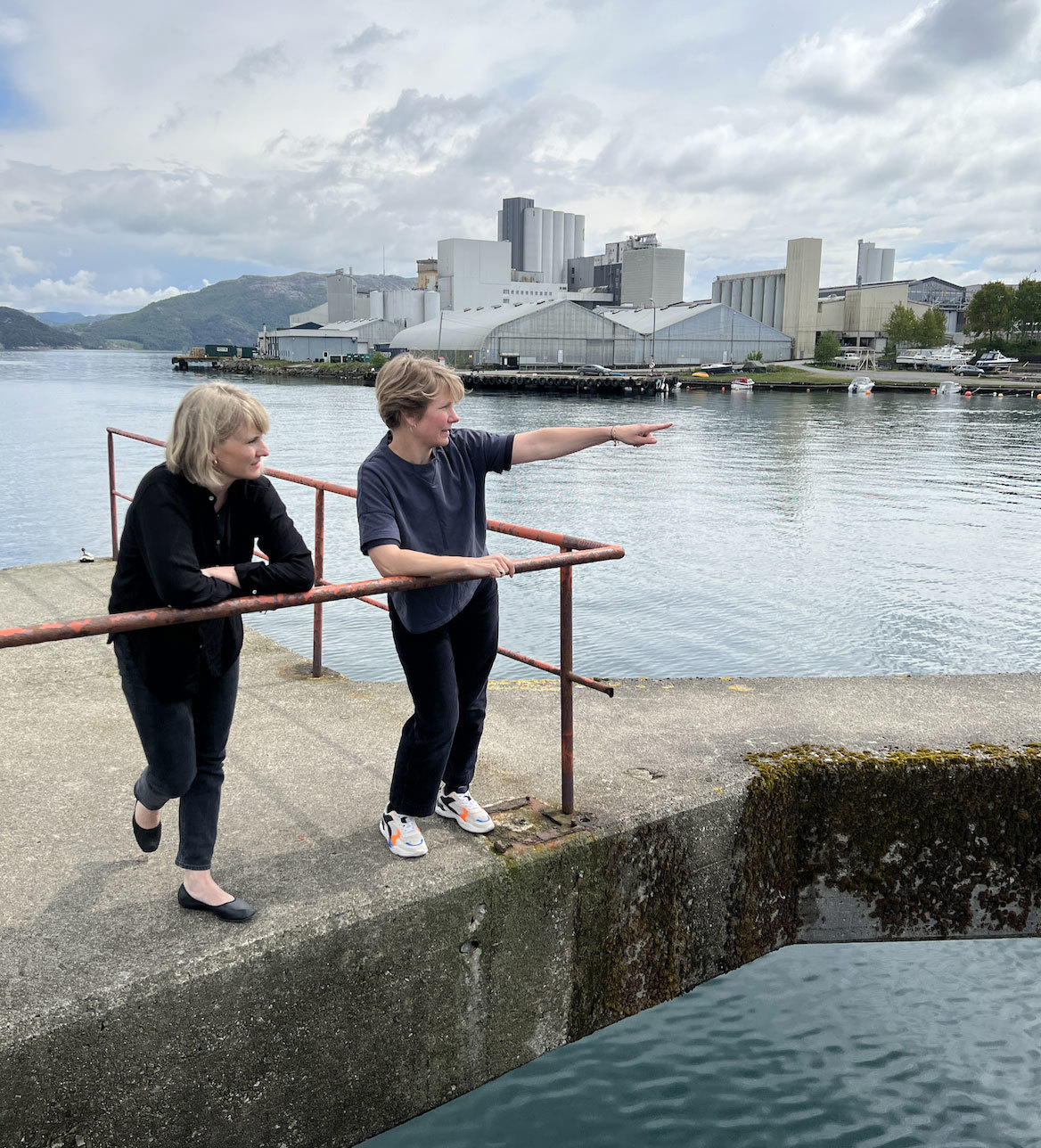 Kanskje kunsten kan få oss til å se stedene langs sjøkanten med et nytt blikk? For eksempel her på Essotomta. Byutvikler Karen Hatleskog Zeiner (t.v.) og Maren Skoie fra kommunens kulturavdeling. (Foto: Sigrun Sætrevik)
