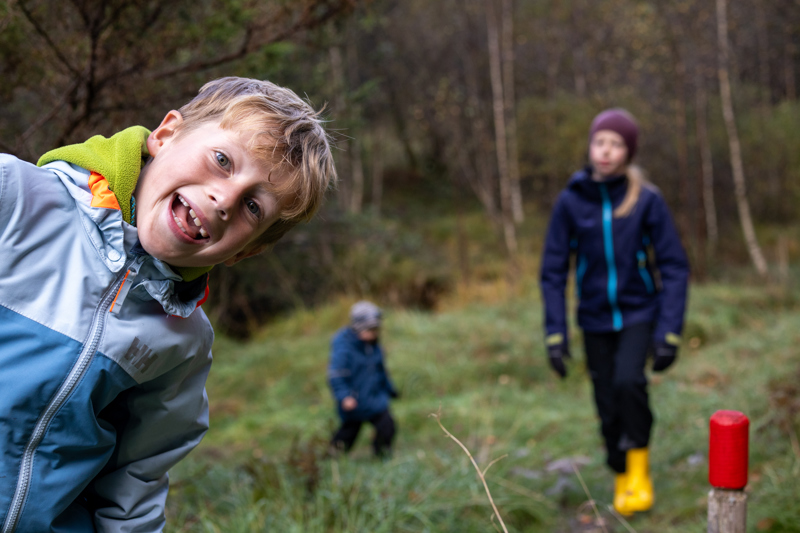 Unge gutter på tur i skogen. 