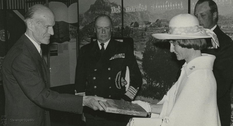 Gammelt bilde som viser en ung kronprinsesse motta en bok med tittelen "De som dro ut". 