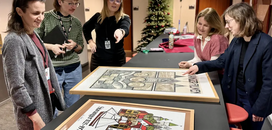 F.v. Astrid Helen Windingstad, Stian Kristensen, Eirill Iren Vigrestad Nord-Varhaug, Sigrun Sætrevik og Goedele Teirlinck.  Juryen står rundt et bord og diskuterer jubileumsplakaten fra 1975.