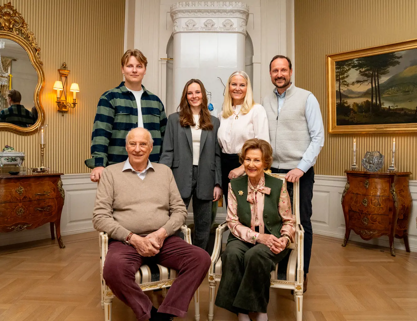 Fremste rekke: H.M. Kong Harald og H.M. Dronning Sonja. Bak, fra venstre: Prins Sverre Magnus, H.K.H. Prinsesse Ingrid Alexandra, H.K.H. Mette-Marit og H.K.H. Haakon Magnus. Foto: Simen Løvberg Sund/Det kongelige hoff. Kongeparet og kronprinsfamilien fotografert innendørs på Bygdø Kongsgård.
