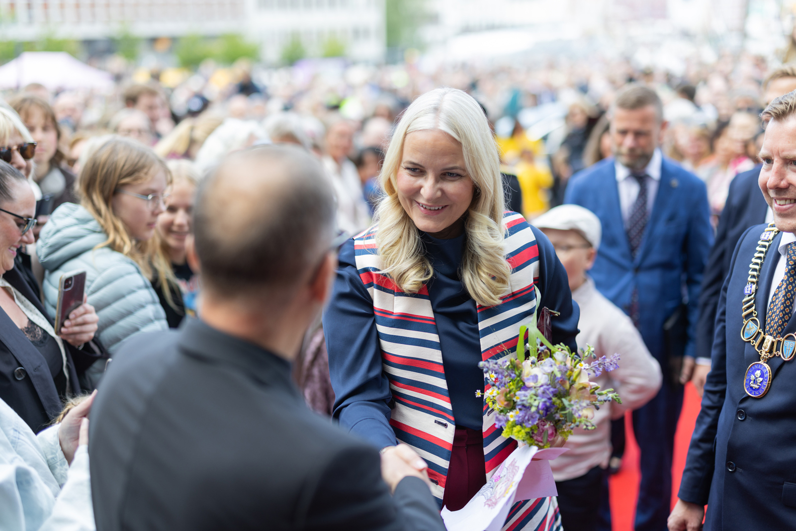 Kronprinsessen hilser på en person i en folkemengde i Stavanger.
