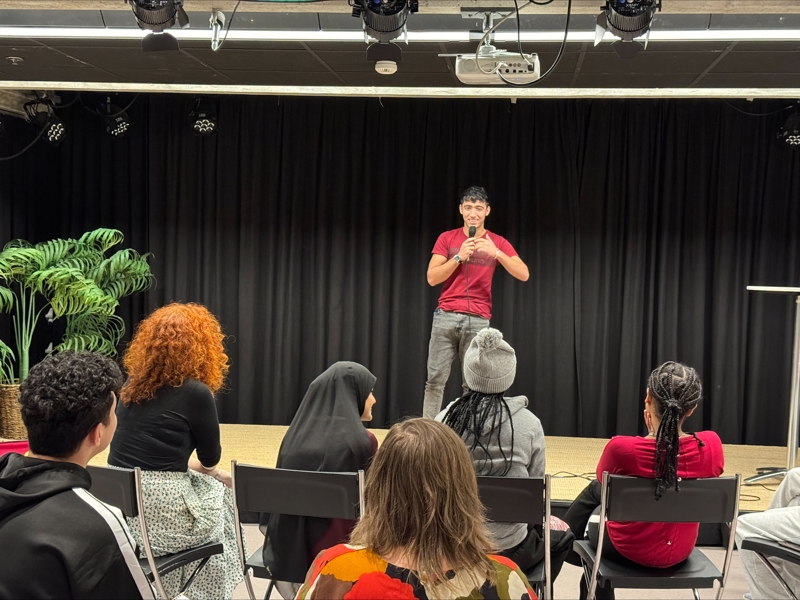 Mohammed står på scene og smiler. 