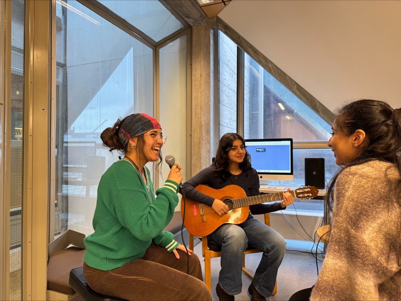 tre venninner som spiller musikk og synger i mikrofon