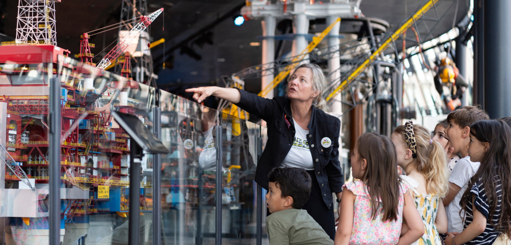 Foto: Shadé B. Martins/Norsk Oljemuseum Voksen kvinne som viser noe til barn på museum.