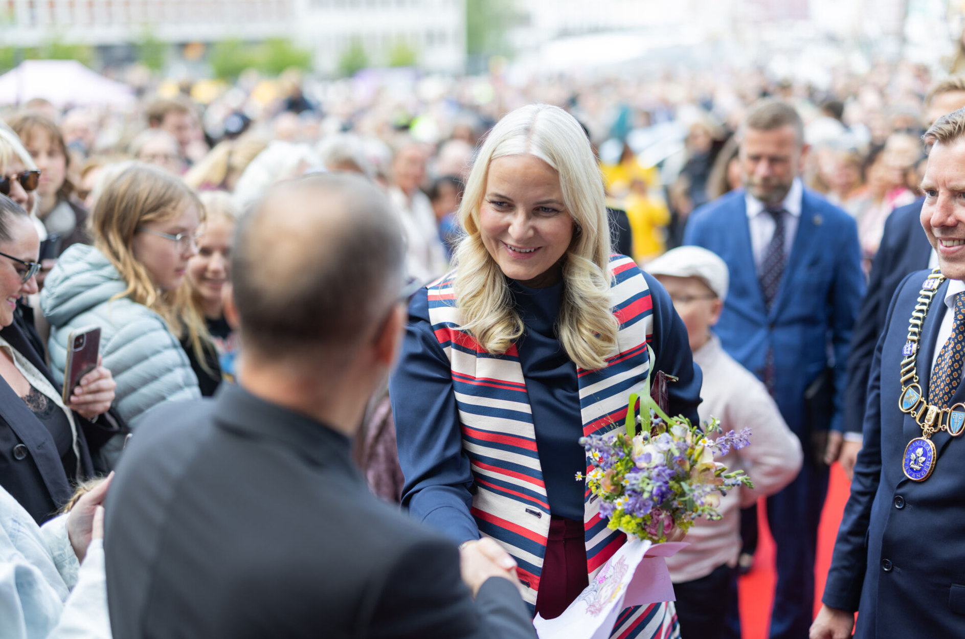 Kronprinsesse Mette-Marit hilser på publikum på vei til domkirken.