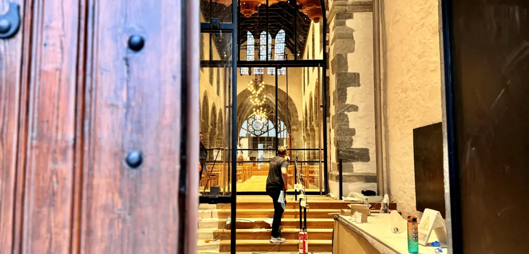 – Her kommer alle inn! De gamle dørene fra 1870-tallet er de samme. De står alltid åpne når kirken er åpen, forteller Live Gram, restaureringsarkitekt i Stavanger domkirke. Inngangsparti i Stavanger domkirke, inn til forhallen.