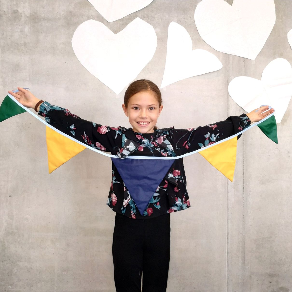 Barn syr for byen Diana S. Pettersen Bilde av et barn med vimpler.