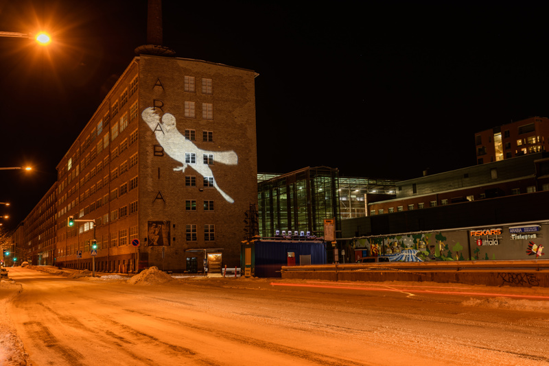 Lysverket HOPE prosjektert på en vegg. En due som lyser.