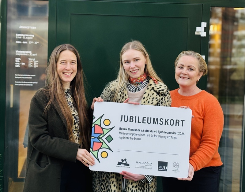 Iselin Grayston, Susanne Sandgren og Siri Vinje poserer sammen med jubileumsårskortet. 