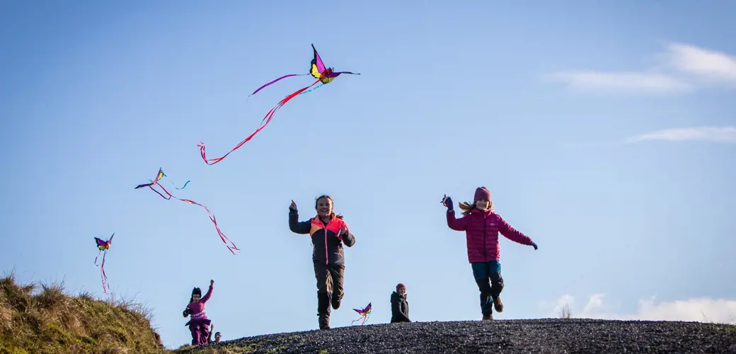 Bildet viser barn som løper med drager på Fjøløy.