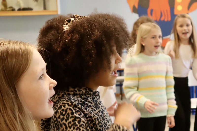 Barn synger og smiler.  