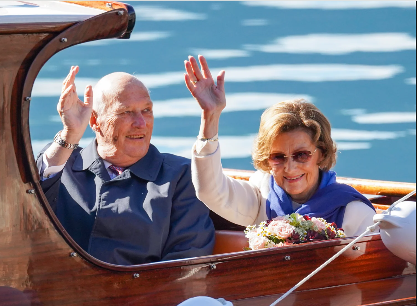 Kong Harald og dronning Sonja vinker.