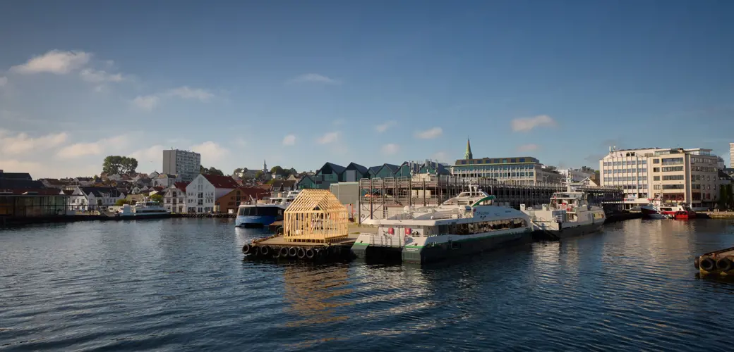 Skaus er et kunstprosjekt som ble etablert i Stavanger i 2019 av kunstnerne Håvard Sagen, Markus Bråten og Mari Kolbeinson. Foto: Håvard Sagen Skaus - trehuskonstruksjon ved Oljemuseet.