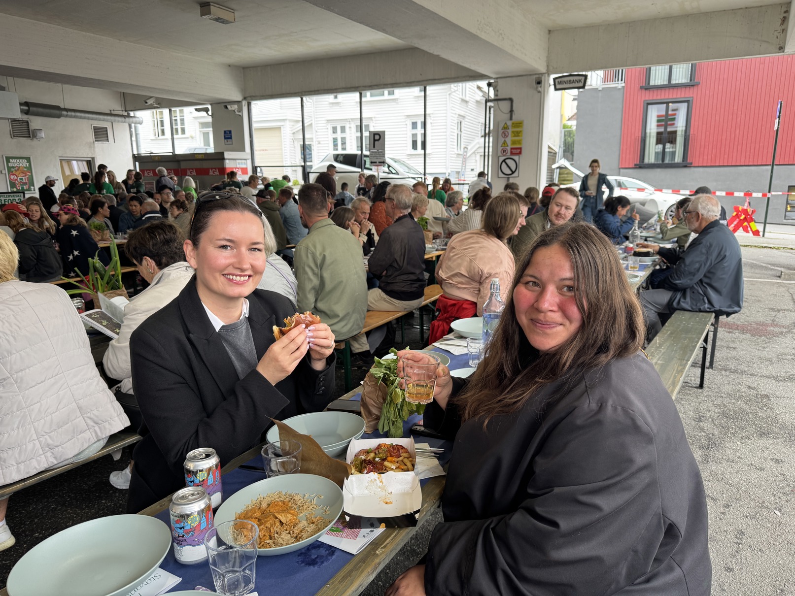 (F.v.) Sandra Vaka og Livie Johansen storkoste seg med blant annet burger fra Hekkan. To venninner sitter på langbord og spiser middag på Blåsenborg.