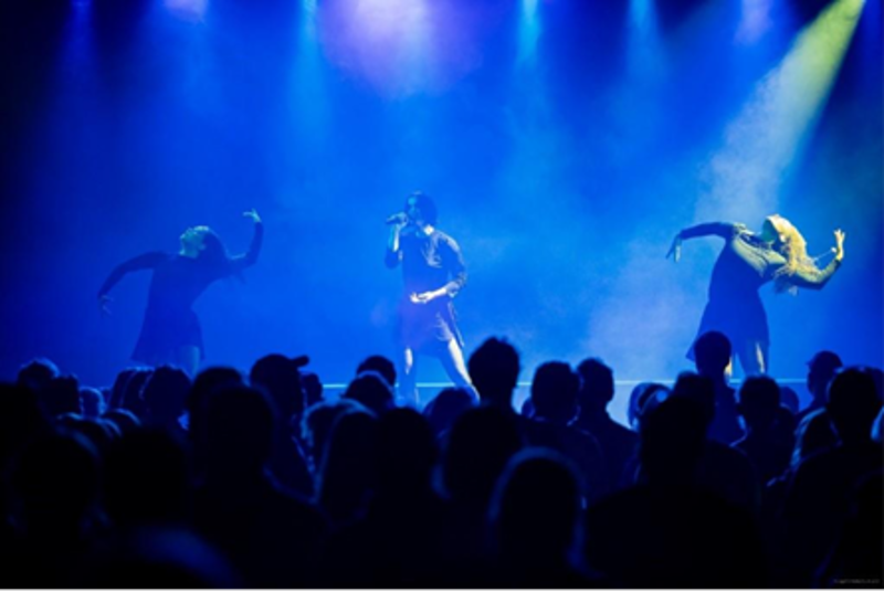 ARY på scenen med dansere ved siden av. 