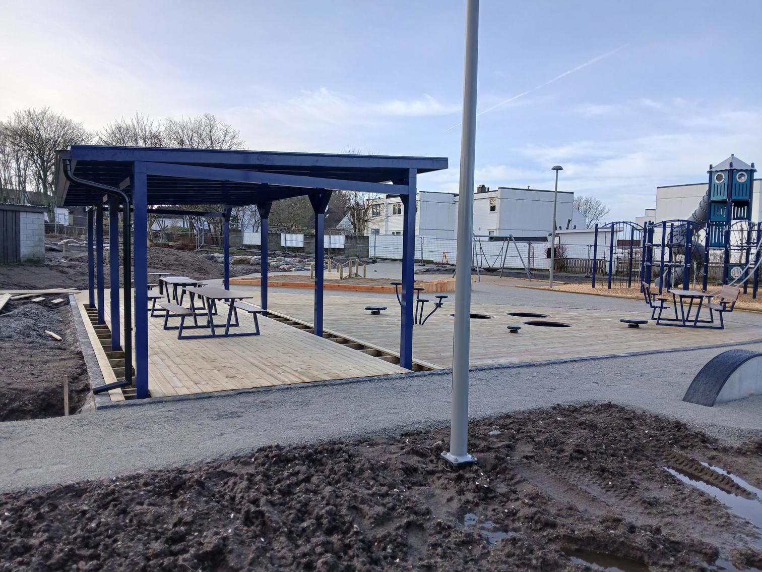 Pergola er satt opp men resten av lekeplassen ligner en byggeplass