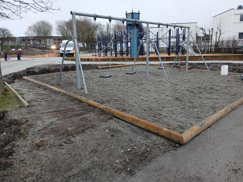 Uferdig lekeplass. Disser i forgrunnen. Lekeslott i bakgrunnen