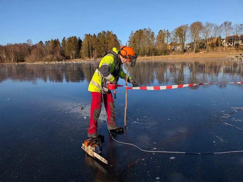 Mann på is som sperrer et utrygt område