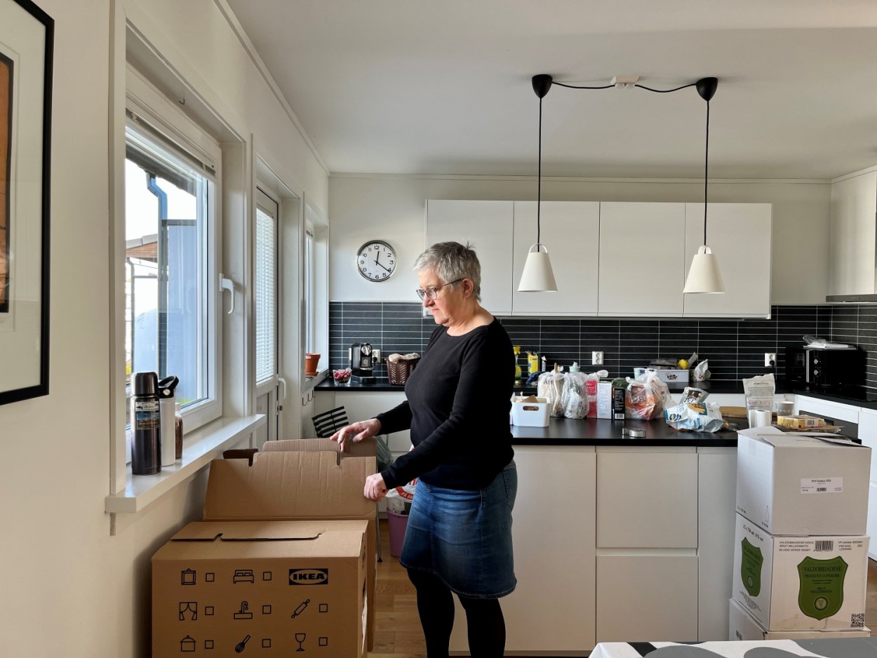 Vi ser Anne Kjersti Medhus som står på kjøkkenet og pakker den ting i flytteesker.