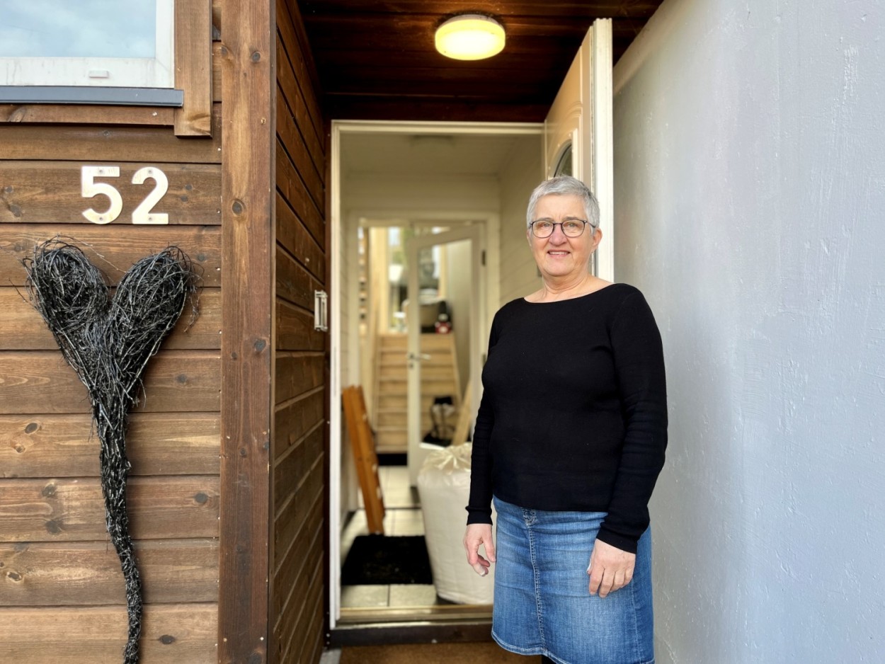 Bildet viser Anne Kjersti Medhus i døråpningen, inngangen på rekkehuset sitt. 