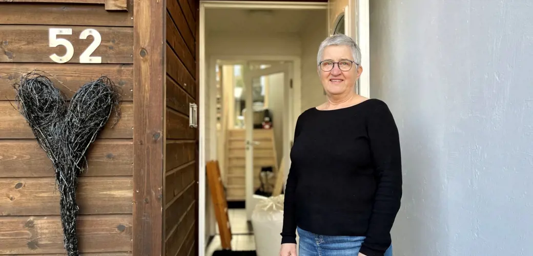 Bildet viser Anne Kjersti Medhus i døråpningen, inngangen på rekkehuset sitt.