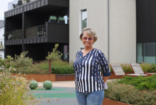 Bente Hopland utenfor i fellesområdet mellom husene og oppgangen til sitt hus.